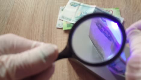 Verification-of-banknotes-by-an-ultraviolet-lamp-for-authenticity.