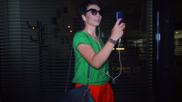 Blogger-in-Sonnenbrille-macht-Video-Übersetzung-von-einem-Smartphone-in-der-Nacht