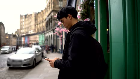 Young-Asian-Man-Casually-Texting-on-Phone-in-Europe