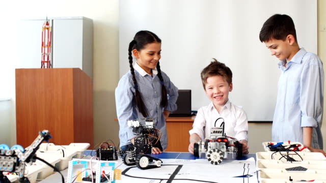 Group-of-kids-choose-parts-of-robotic-toys-for-building-robots-at-school-lesson