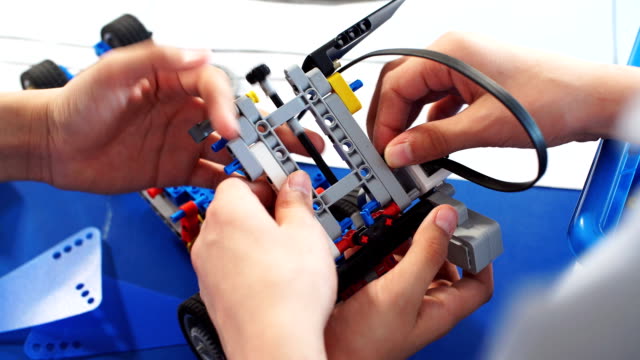 Kinder-spielen-mit-Elektroroboter-beim-Besuch-der-Robotik-Ausstellung