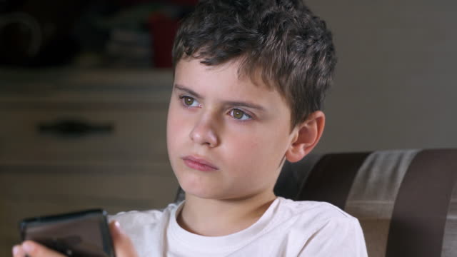 Closeup-portrait-of-a-sad-teenager-boy-with-a-phone.-He-saw-something-sad-on-his-smartphone.-Social-media-and-child.-Cellphone-technology.-Phone-and-childhood.-Kid-and-telephone.-Cell-and-gadget.