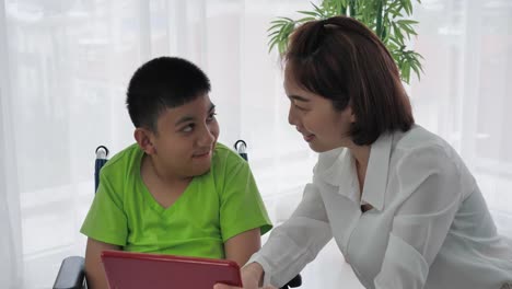 Mother-and-son-with-disability-in-a-wheelchair-Using-Digital-Tablet