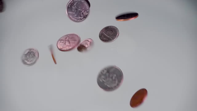Metall-Münzen-(Cent)-fallen-auf-eine-glänzend-weiße-Leuchtfläche