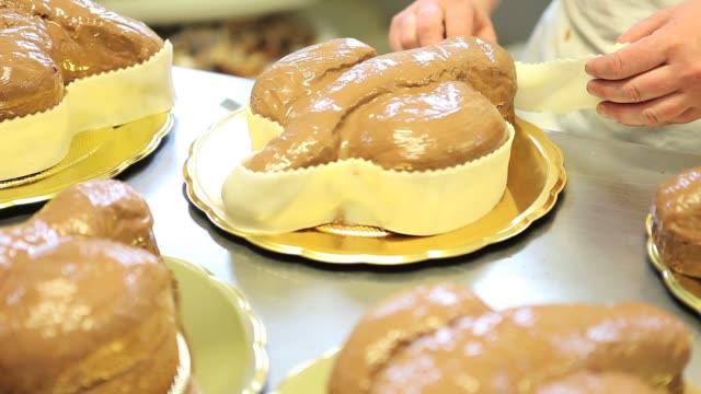 manos-de-chef-de-pastelería-decorar-Pascua-pasta-de-tortas-de-pan-dulce-con-azúcar-de-fondants,-closeup-en-la-encimera-en-confitería