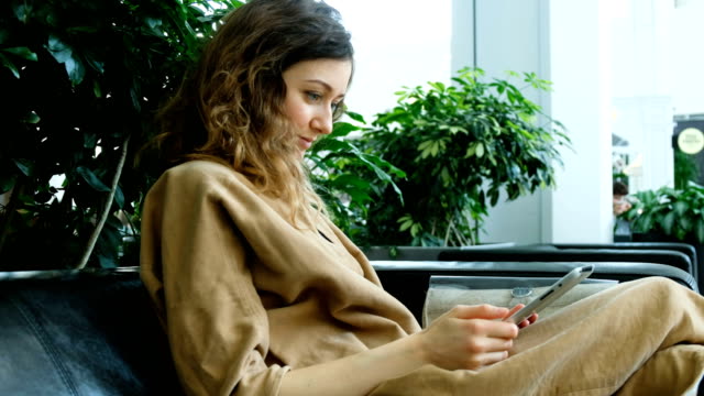 Empresaria-sentado-en-el-sofá-business-center-y-uso-de-una-tableta