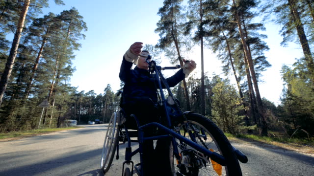 Hombre-discapacitado-utiliza-equipo-especial-para-mover-en-una-carretera,-cerca.