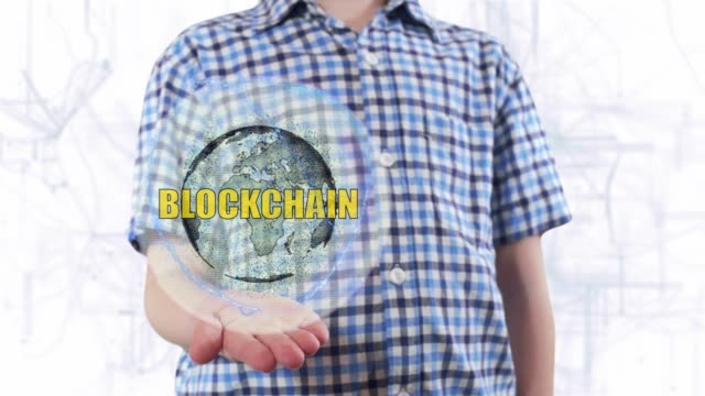 Young-man-shows-a-hologram-of-the-planet-Earth-and-text-Blockchain