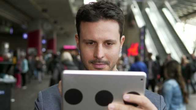 Kaukasische-Mitarbeiter-online-und-mobil-am-Bahnhof-mit-digital-Tablette