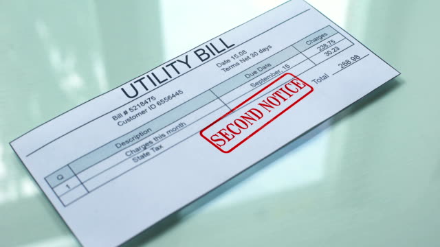 Segundo-aviso-de-factura-de-electricidad,-mano-estampando-sello-en-documento,-pago-de-servicios
