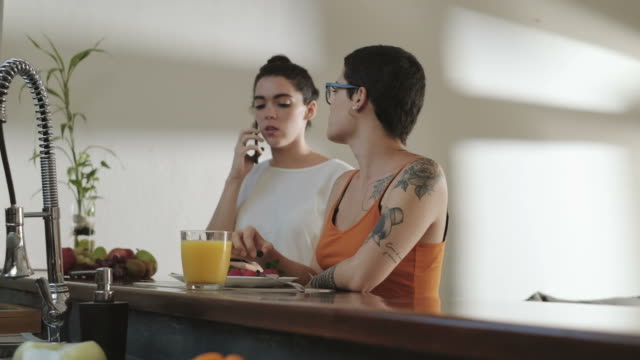 Las-mujeres-homosexuales-chicas-socios-comer-fruta-y-hablando-en-el-teléfono