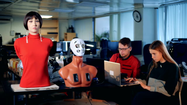 Zwei-Ingenieure-beobachten-ein-Roboter-Mannequin-Gesichts-Organe-bewegen