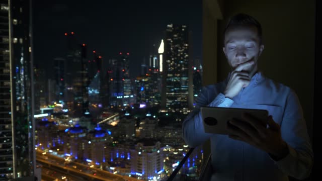 Caucasian-man-using-digital-tablet-for-internet-and-communications-with-cityscape-background
