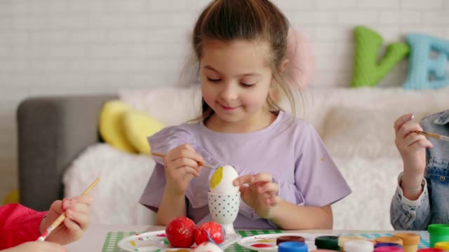 Close-up-of-focused-girl-painting-easter-egg