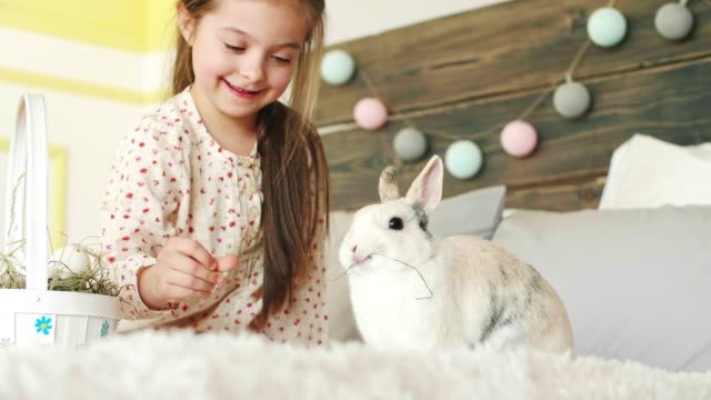 Lächelnde-Mädchen-füttert-das-Kaninchen