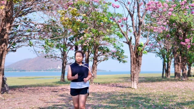An-Asian-woman-jogging-in-natural-sunlight-in-the-morning.
She-is-trying-to-lose-weight-with-exercise.--concept-health-with-exercise.