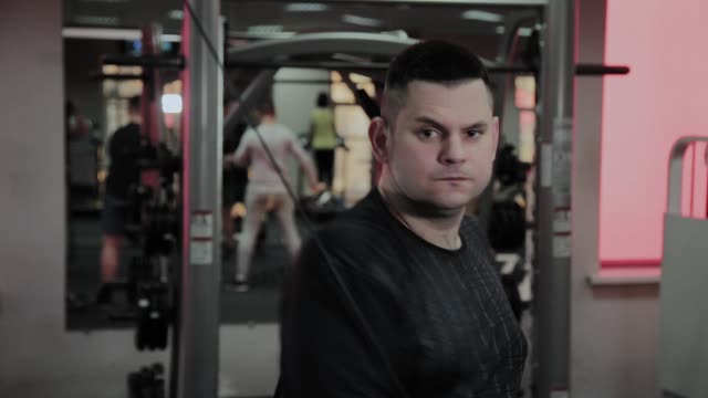 Hombre-gordo-alegre-realiza-un-ejercicio-equivocado-en-el-gimnasio.-Por-primera-vez-en-un-club-de-fitness