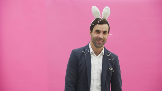 Young-sexy-couple-on-pink-background.-With-hackneyed-ears-on-the-head.-During-this-reproduction-sexual-rabbit-movements-and-looks,-after-a-while-go-out-of-the-frame.