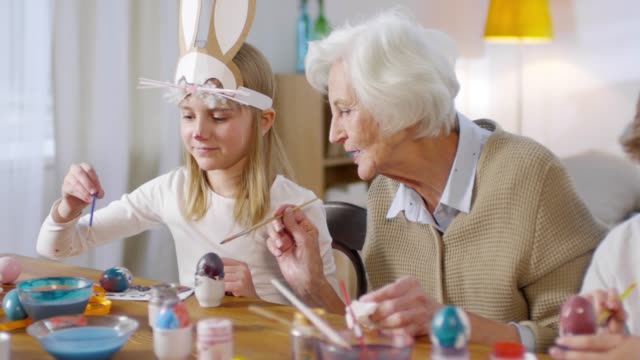 Entzückende-Kinder-und-Großmutter-Malerei-Eier