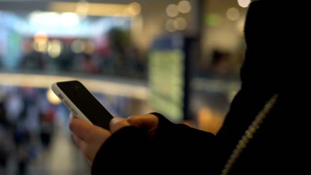 Female-typing-on-smartphone,-standing-in-shopping-center,-online-banking