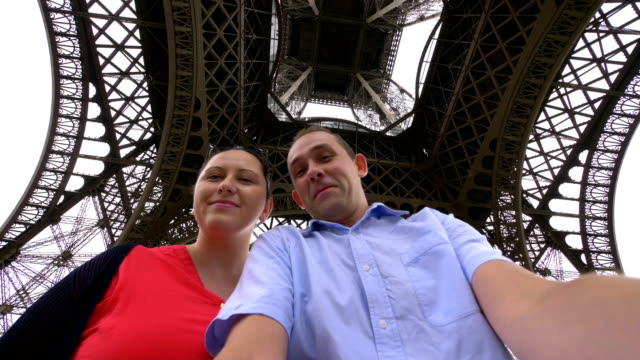 Pareja-tomando-selfie-con-una-vista-de-la-Torre-Eiffel-en-París-en-4k-cámara-lenta-60fps