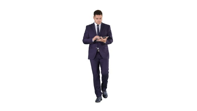 Man-in-suit-walking-and-using-digital-tablet-on-white-background