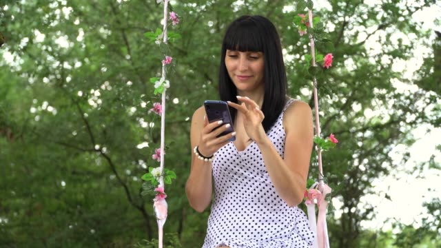 schöne-junge-Mädchen-kommuniziert-im-Internet-mit-einem-Smartphone,-in-der-Natur