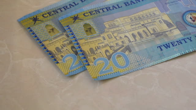 Un-primer-plano-del-Banco-Central-de-Omán-20-letras-de-efectivo-Riyal,-la-moneda-de-los-billetes-de-Omán-repartido-sobre-un-fondo-semi-blanco.-Intercambio-de-dinero.