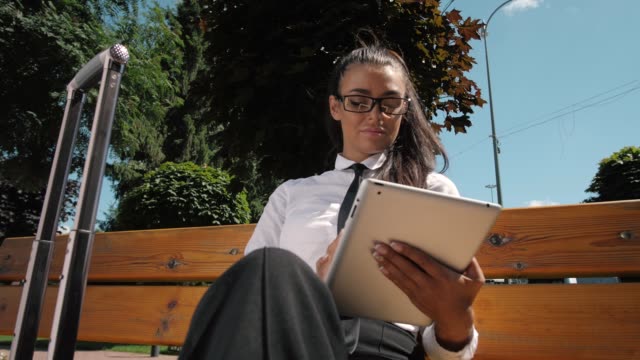 Mujer-leyendo-Tablet-Tablet-Device.-Una-joven-adulta-española-latina-compra-online-reservando-al-aire-libre-en-la-calle,-terminal-del-aeropuerto