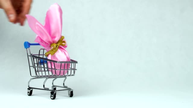 Wrapped-Easter-egg-is-placed-into-the-toy-shopping-cart-during-Resurrection-Sunday-or-Christian-feast-Pascha