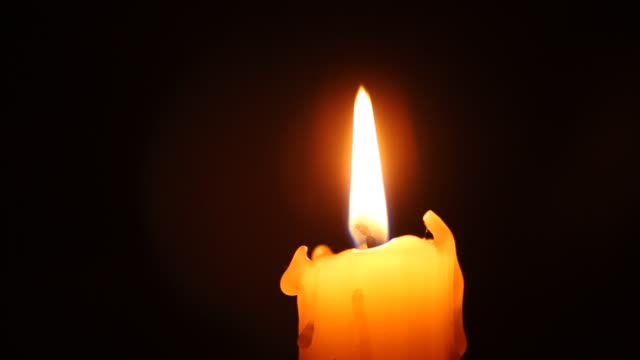 Closeup-of-candle-flame-on-black.-Old-white-candle