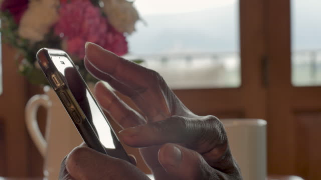 Kippen-Sie-die-Hände-einer-schwarzen-Frau-kneifen-und-verwenden-Sie-ein-Smartphone
