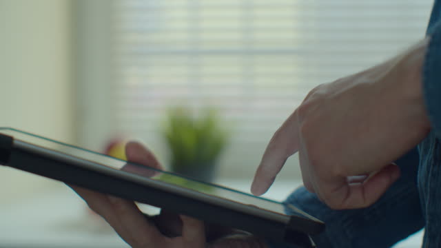 Businessman-using-tablet-computer-online-shopping-working-from-home.-Close-up.