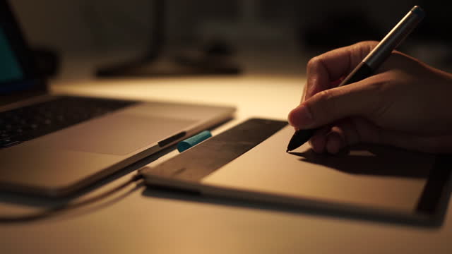 Close-up-view-of-graphic-designer-hand-using-graphics-tablet-working-over-night