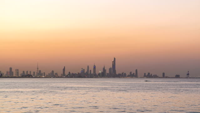 Skyline-mit-Wolkenkratzern-Tag-zur-Nacht,-Timelapse-in-Kuwait-Stadt-Innenstadt-beleuchtet-bei-Dämmerung.-Kuwait-Stadt,-Naher-Osten