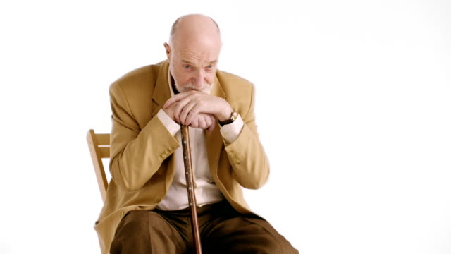 Sad-lonely-old-man-with-piercing-eyes-sitting-in-an-armchair-with-his-cane