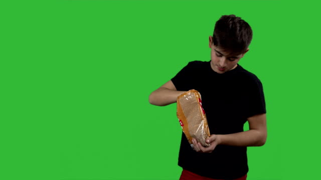 boy-eating-potato-chips-on-a-green-background.-Teen-boy-eating-junk-food