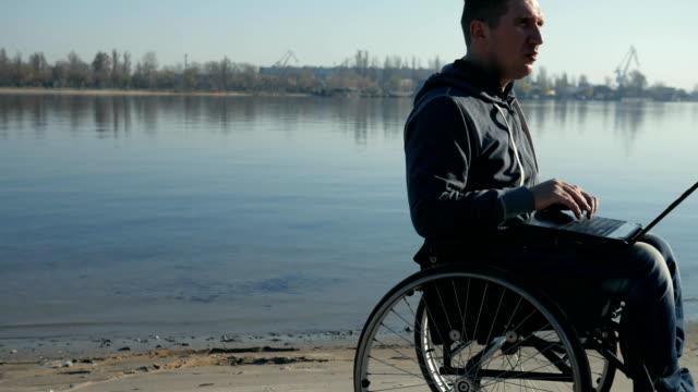 Porträt,-die-behinderte-Person-mit-Laptop,-auf-Rollstuhl-führt-video-chat