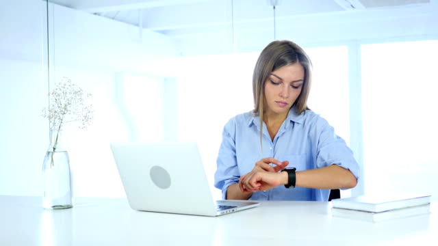 Junge-Frau-mit-Smartwatch,-sitzen-im-Büro