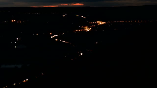 Night-city-Highway.-Car-traffic-on-night-road.-Setting-sun.-The-river,-mountains-time-lapse.