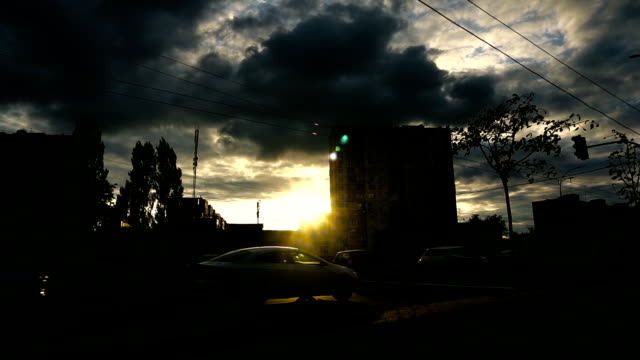 Sonnenuntergang-Strahlen-und-Straße-mit-dem-Bau-im-Wolkengebilde-Hintergrund