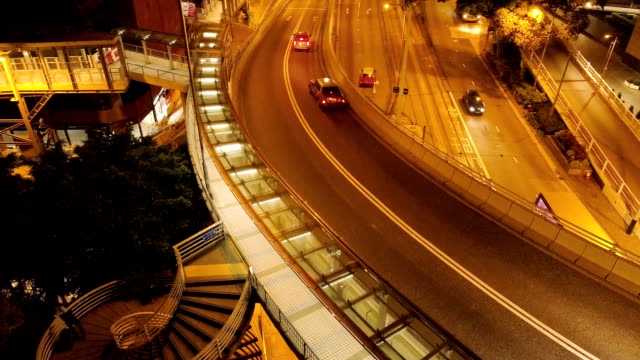 Vista-superior-de-tráfico-en-el-puente-de-Hong-Kong.-Stock.-Cruce-de-un-puente-y-una-carretera-con-luces-de-vehículo-formando-senderos-de-luz-en-Hong-Kong-en-la-noche