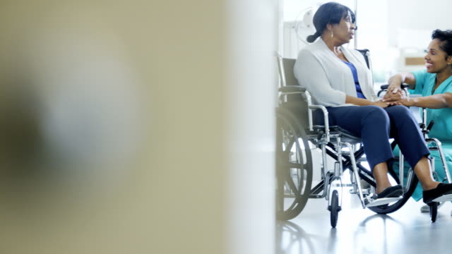 Multi-ethnischen-Team-mit-älteren-Patienten-im-Rollstuhl
