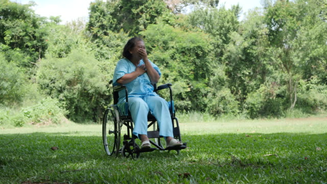 Lonely-disabled-elderly-woman-sitting-on-wheelchair-alone-in-the-park