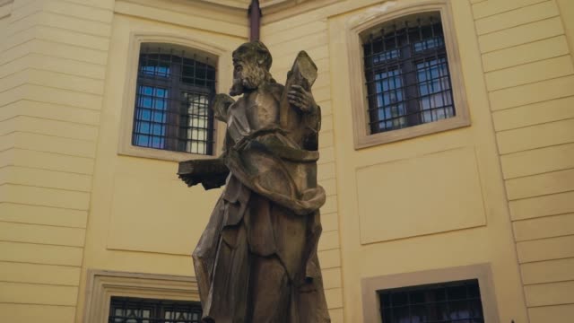 Blick-auf-die-Statue-von-Salbei-mit-einem-Buch-in-seinen-Händen-auf-dem-Hintergrund-der-Stadtarchitektur.