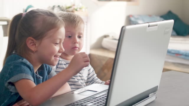 Poco-los-niños-viendo-dibujos-animados-en-computadora-portátil