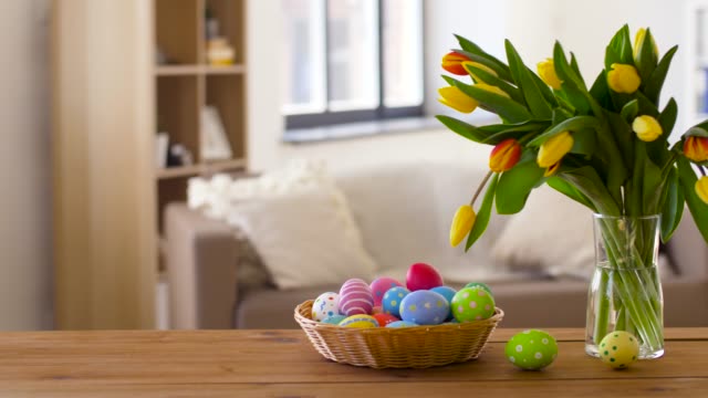 huevos-de-Pascua-en-cesta-y-tulipán-flores-en-casa