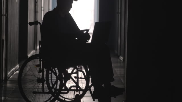 Silhouette-der-behinderte-Mensch-am-Rollstuhl-mit-Laptop-und-Smartphone