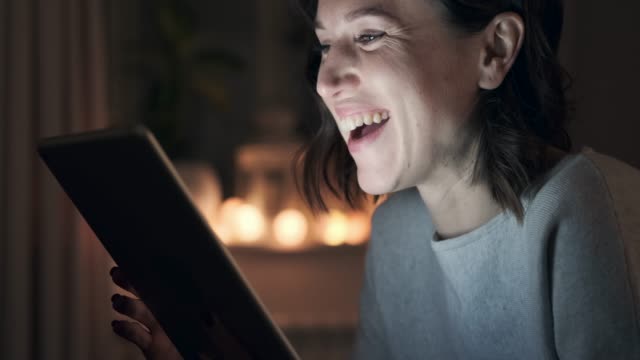 Mujer-teniendo-diversión-con-tableta-digital-en-la-noche