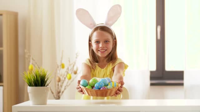 happy-girl-showing-colored-easter-egg-at-home